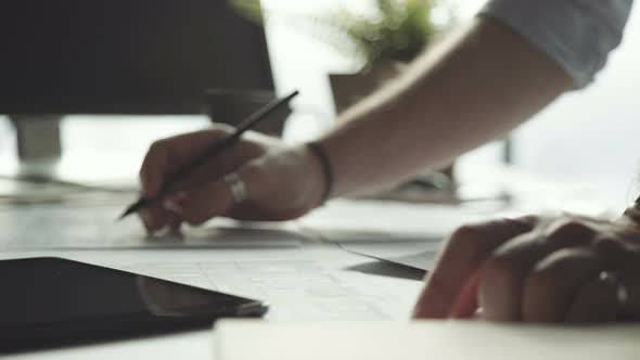 Businessman with Stylish Rings on Fingers Writes with a Pencil