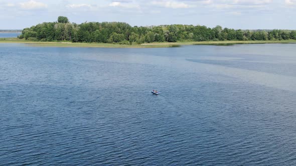 Aerial View of People Traveling on Lake in a Canoe With Forest in Background Ascending Revealing Hor