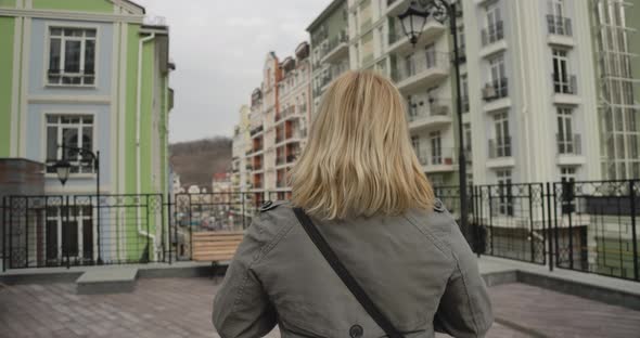 Back View Close-up of Blond Woman in Autumn Coat Standing on City Street. Senior Caucasian Retiree