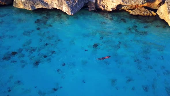 Aerial view of a person snorkeling on the shore of Cas Abao Beach, Dutch island of Curacao in the Ca