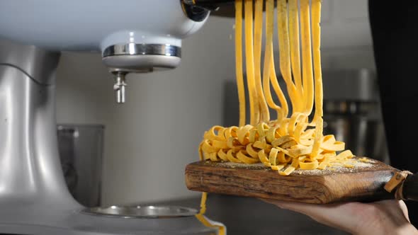 Traditional Italian Cuisine. Making Homemade Pasta, Close-up of Chef Makes Pasta Using Steel Machine