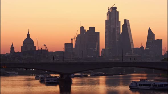 Morning sunrise behind St Paul's Cathedral and the City of London with Waterloo bridge in foreground