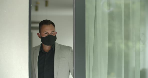Man in Mask Opening a Door
