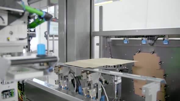 Automatic packaging machine stores products in cardboard boxes.