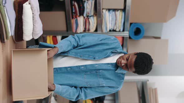 Multiracial Volunteer Selecting Clothes for Recycle or Donating and Putting It Into the Cupboard Box