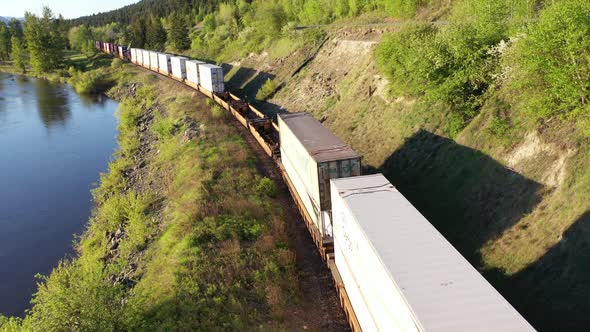 Aerial view of freight train passing by a river