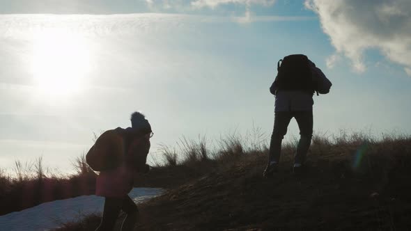 Couple Hiking Help Each Other Silhouette in Mountains