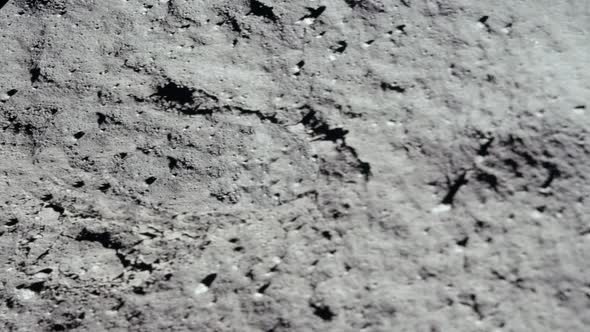 Lunar astronaut walking on the moon's surface and leaves a footprint in the lunar soil