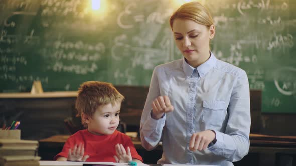 Young Beautiful Teacher and Toddler Pupil Playing at Kindergarten.