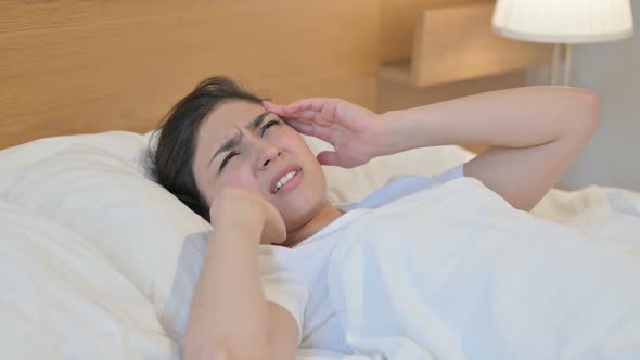 Young Indian Woman having Headache while Sleeping in Bed