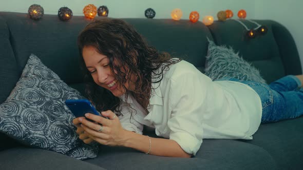 Beautiful Young Woman with Mobile Phone at Home