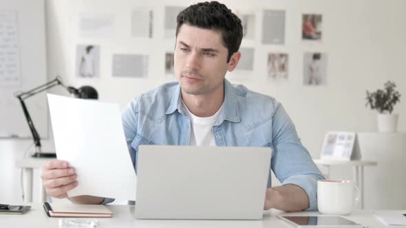 Casual Young Man Reading Documents