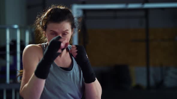 Woman Shadow Fighting in Gym and Looking at Camera