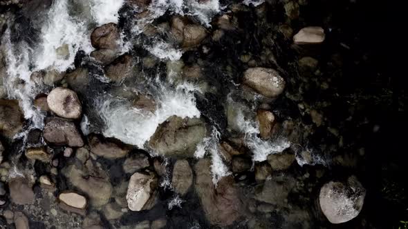 Top view of a waterbed full of rocks in a coloration close to black and white