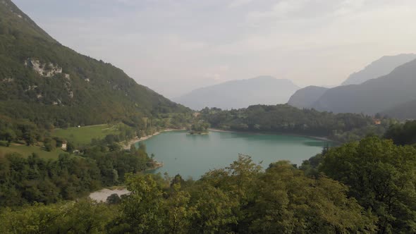 Aerial view of Tenno lake, Trentino, North Italy. Green landscape during a sunny day. Drone goes up