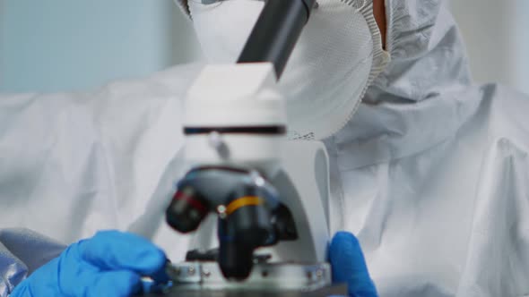 Close Up of Experienced Biologist in Ppe Suit Working on Microscopes