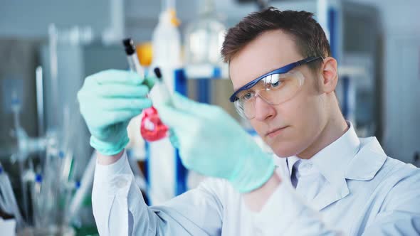 A Young Man Doing an Experiment in a Chemical Laboratory