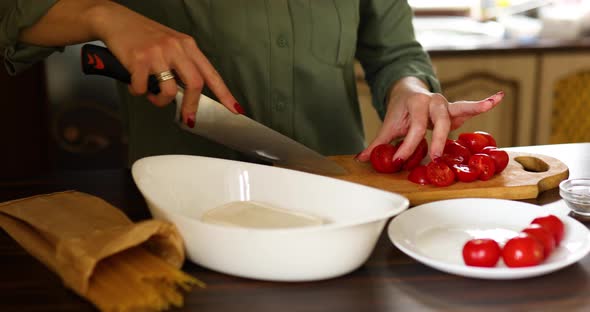 Step by step woman cooking feta cheese pasta, cutting tomatoes,