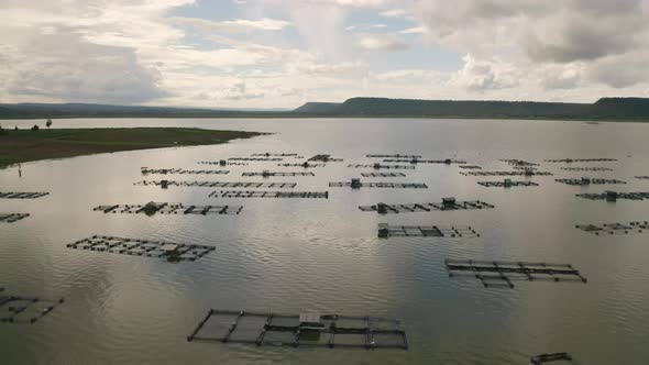 Aerial view of local fishing trap net in canel with fisherman home, lake or river at sunset. Nature