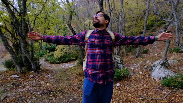 Satisfied Traveler Guy Stands in Picturesque Forest