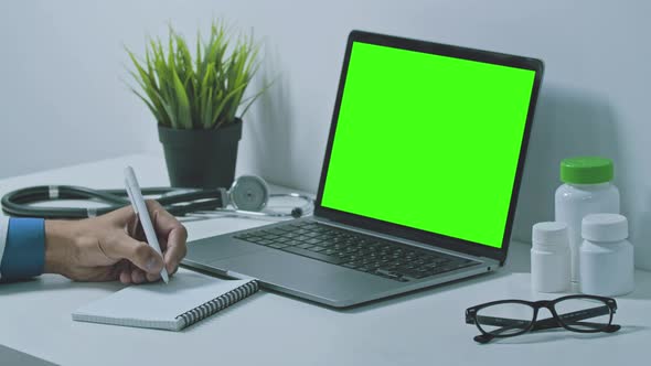 Doctor Consulting Distant Patient via Online Video Conference Using Laptop.