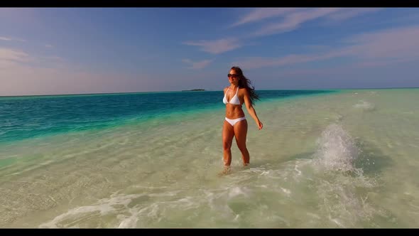 Lady alone sunbathes on tropical seashore beach wildlife by turquoise ocean and white sand backgroun