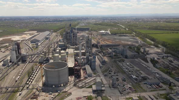 Aerial view of cement factory with high concrete structure and tower crane at industrial