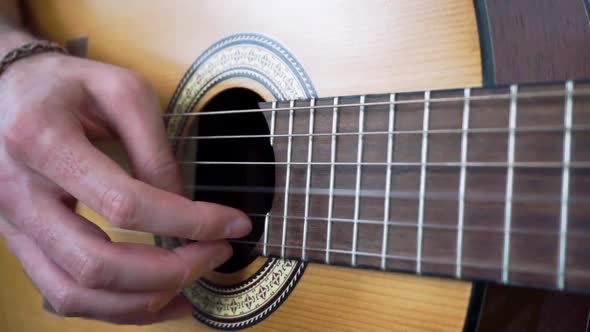 Male lightly picking acoustic guitar