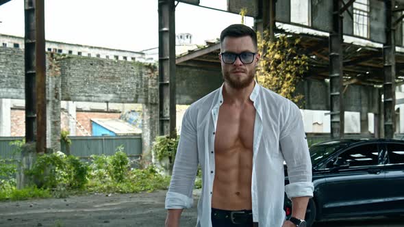 Strong guy with naked torse. Muscular young macho man with bare torso in white shirt and glasses