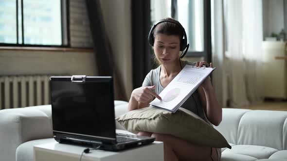 woman working remotely from home using laptop and headset