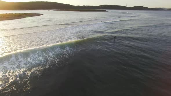 Drone View of Surfers Waiting for a Wave in the Sea at Sunset