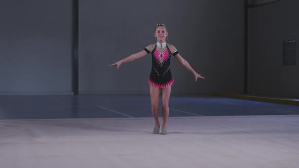 Teenage female gymnast performing at sports hall