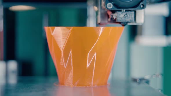 3Dprinting Machine is Producing an Orange Vase