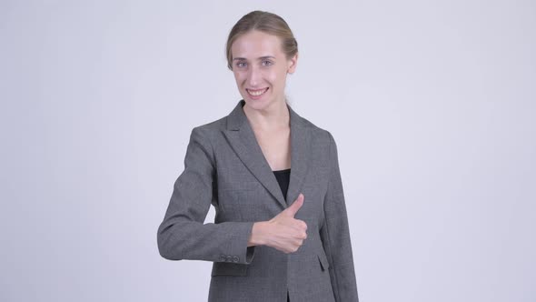 Happy Young Blonde Businesswoman Giving Thumbs Up