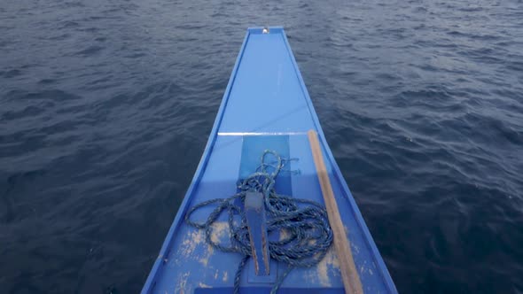Ultra slow motion shot of front of traditional filipino bangka boat sailing on blue waters towards l