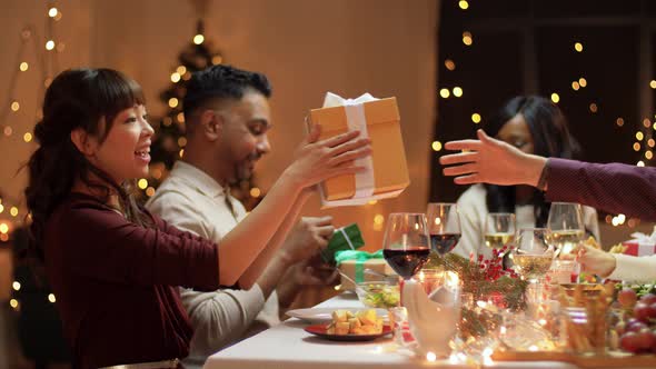 Friends Having Christmas Feast and Giving Presents