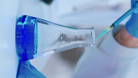 Vertical Video Close Up of Scientist Filling Test Tube with Liquid Using Pipette