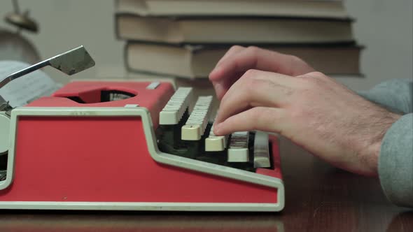 Man's Hands Typing on a Red Typewriter