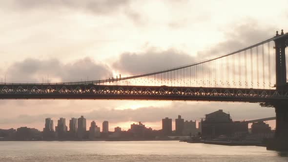 AERIAL: Flight Under Brooklyn Bridge at Sunrise in New York City 