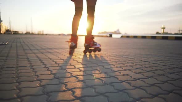 Young Stylish Funky Girl with Green Hair Riding Roller Skates and Dancing Near Sea Port During