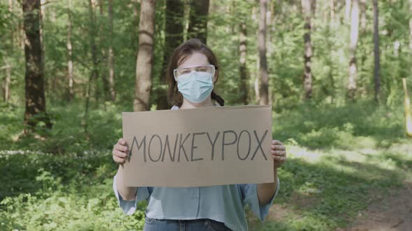 Woman in Glasses Mask with Poster is Worried About Outbreak of Monkeypox