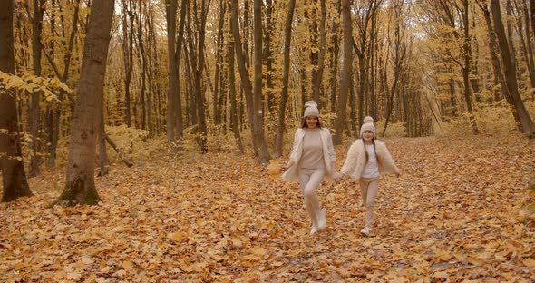 Mother Walking with Preteen Daughter in Autumn Park