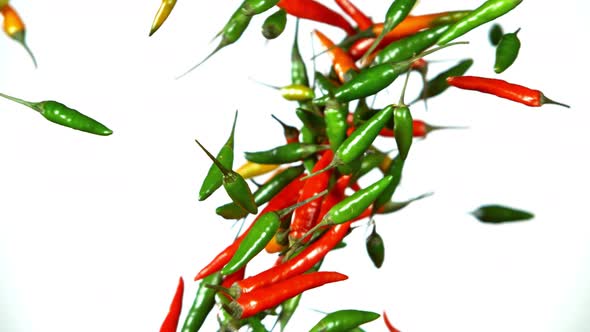 Super Slow Motion Shot of Mixed Chilli Side Colision Isolated on White Background at 1000Fps.