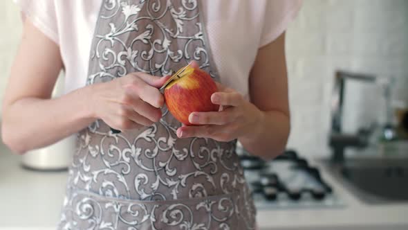 Woman Peeling Apple at Kitchen