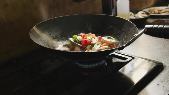Chef adding vegetables on the pan