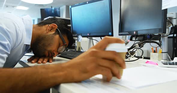 Male executive sleeping at desk