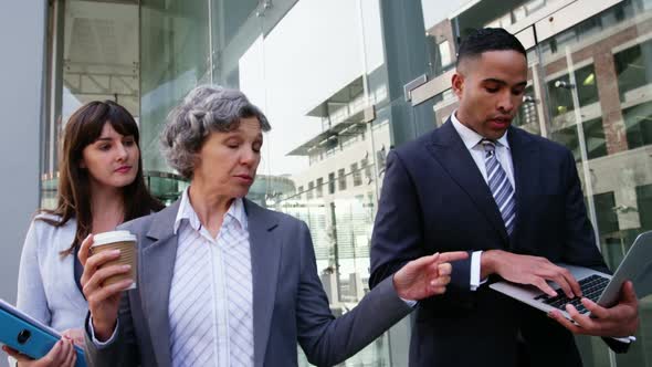 Business people interacting with each other while walking