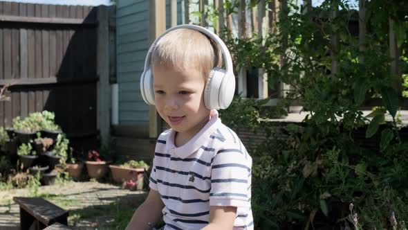 Portrait of Cute Little Boy With Headphones Listening to Music