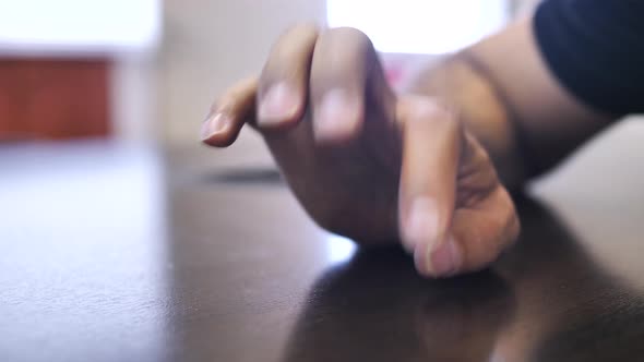 Nervous man tapping fingers on table. Close up