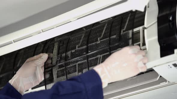 close up technician service removing air filter of the air conditioner for cleaning